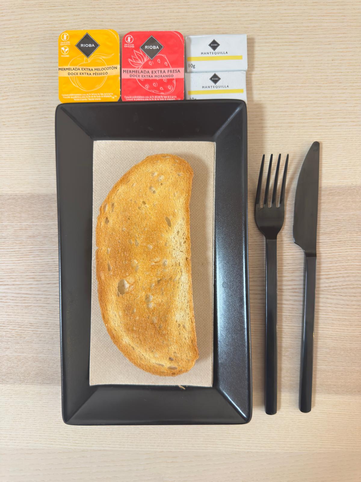 Tostada de mantequilla, mermelada de melocoton o fresa